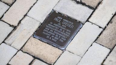  Ein Stolperstein, zur Erinnerung an NS-Opfer Paul Gröger, ist vor dem Rathaus in den Fußweg eingelassen.