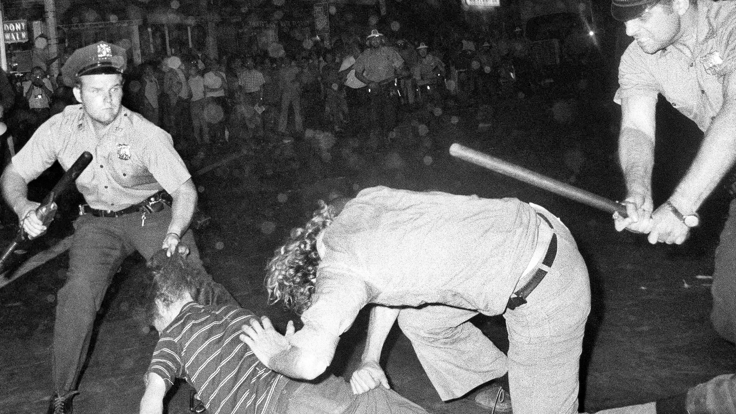 Polizeibeamte gehen mit Schlagstöcken gegen Männer vor, die am Gay Power March in Greenwich Village teilnehmen.