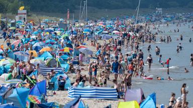  Zahlreiche Badegäste sind bei sonnigem Wetter am Ostseestrand in Mecklenburg-Vorpommern.