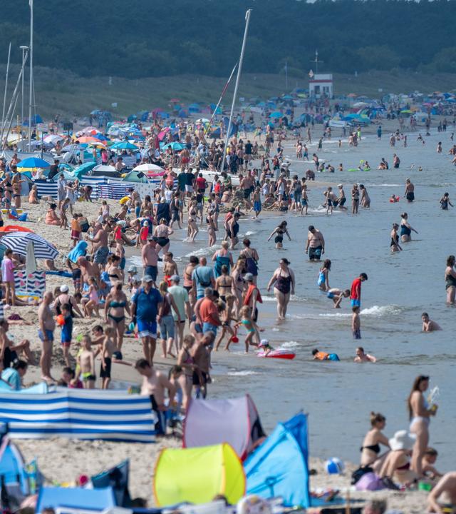  Zahlreiche Badegäste sind bei sonnigem Wetter am Ostseestrand in Mecklenburg-Vorpommern.
