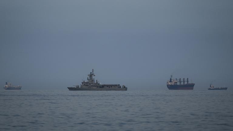 11.03.2026, Vereinigte Arabische Emirate, Khor Fakkan: Ein Schiff der Marine der Vereinigten Arabischen Emirate patrouilliert neben Frachtschiffen und Öltankern in der Straße von Hormus am 11.03.2026 in Khor Fakkan, Vereinigte Arabische Emirate.