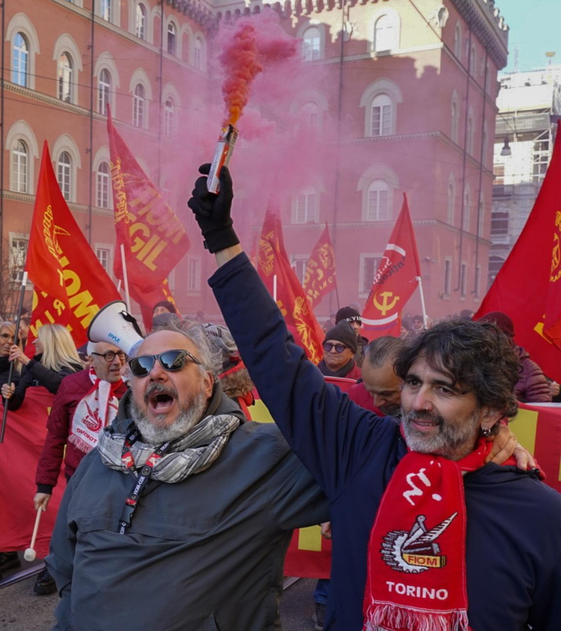 Demonstranten mit Rauchfahnen sind in Turin auf einer Straße unterwegs. In Italien hat ein großangelegter Streik gegen die Haushaltspläne der Rechtsregierung von Ministerpräsidentin Meloni begonnen.