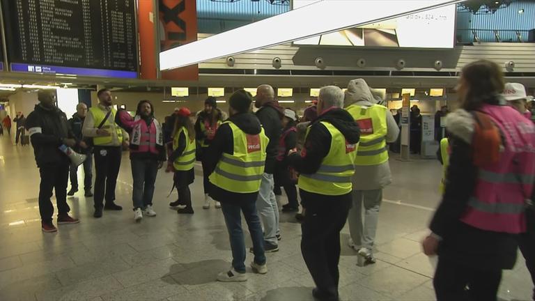 Auf dem Bild sieht man Menschen am Flughafen die streiken.