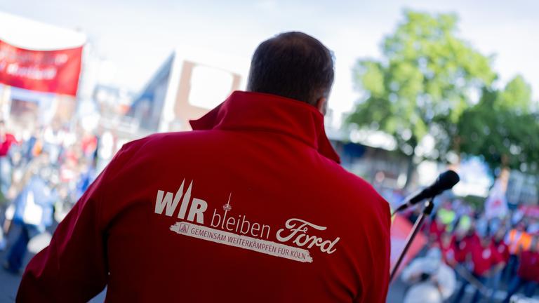  Ein Mitarbeiter trägt eine Jacke mit der Aufschrift Wir bleiben Ford - Gemeinsam weiterkämpfen für Köln beim ersten Streik der Geschichte vor den Kölner Ford-Werken. 