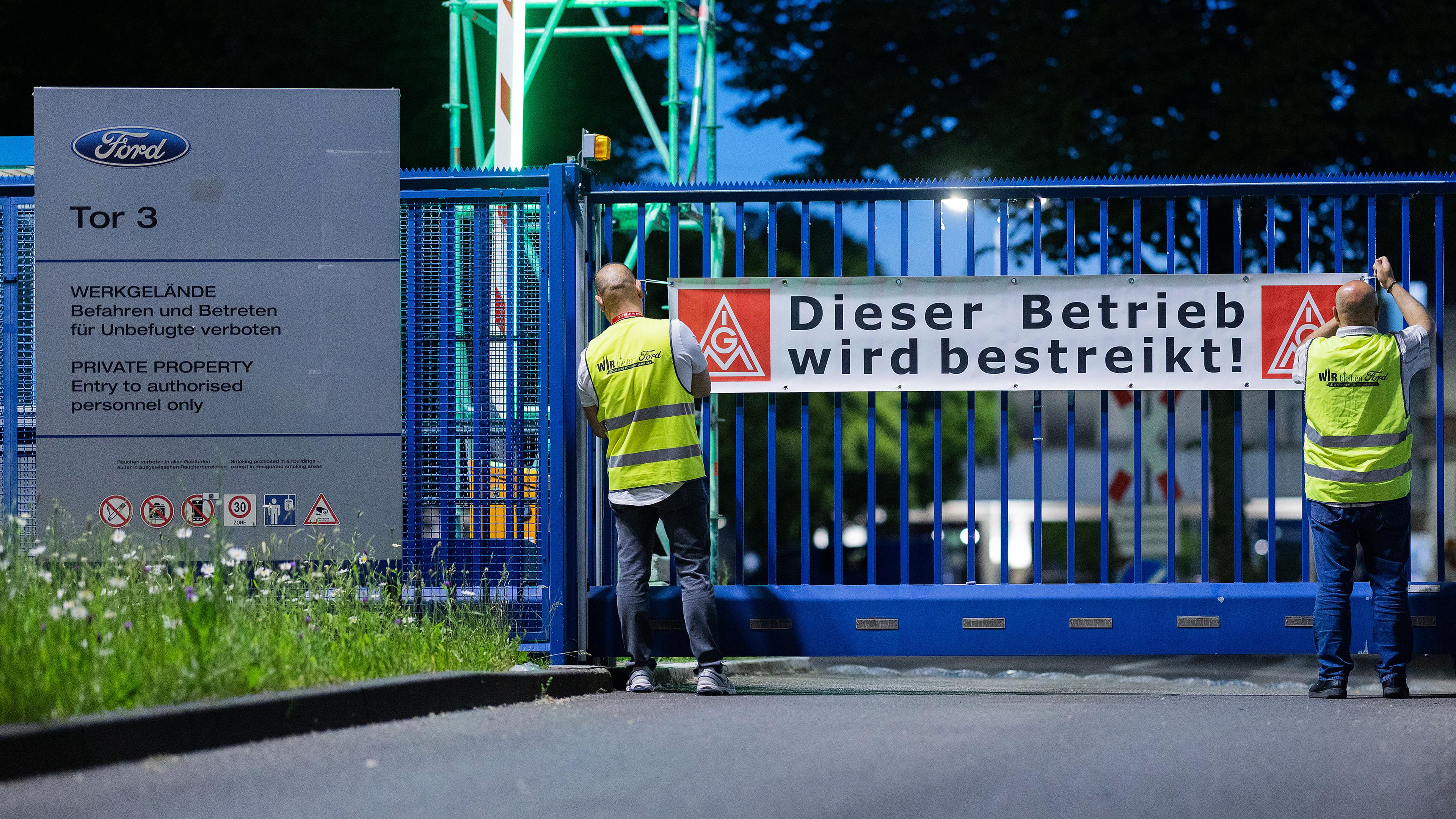 Mitarbeiter bringen beim ersten Streik in der Geschichte der Kölner Ford-Werke ein Banner vor dem Haupttor 3 an mit der Aufschrift Dieser Betrieb wird bestreikt!