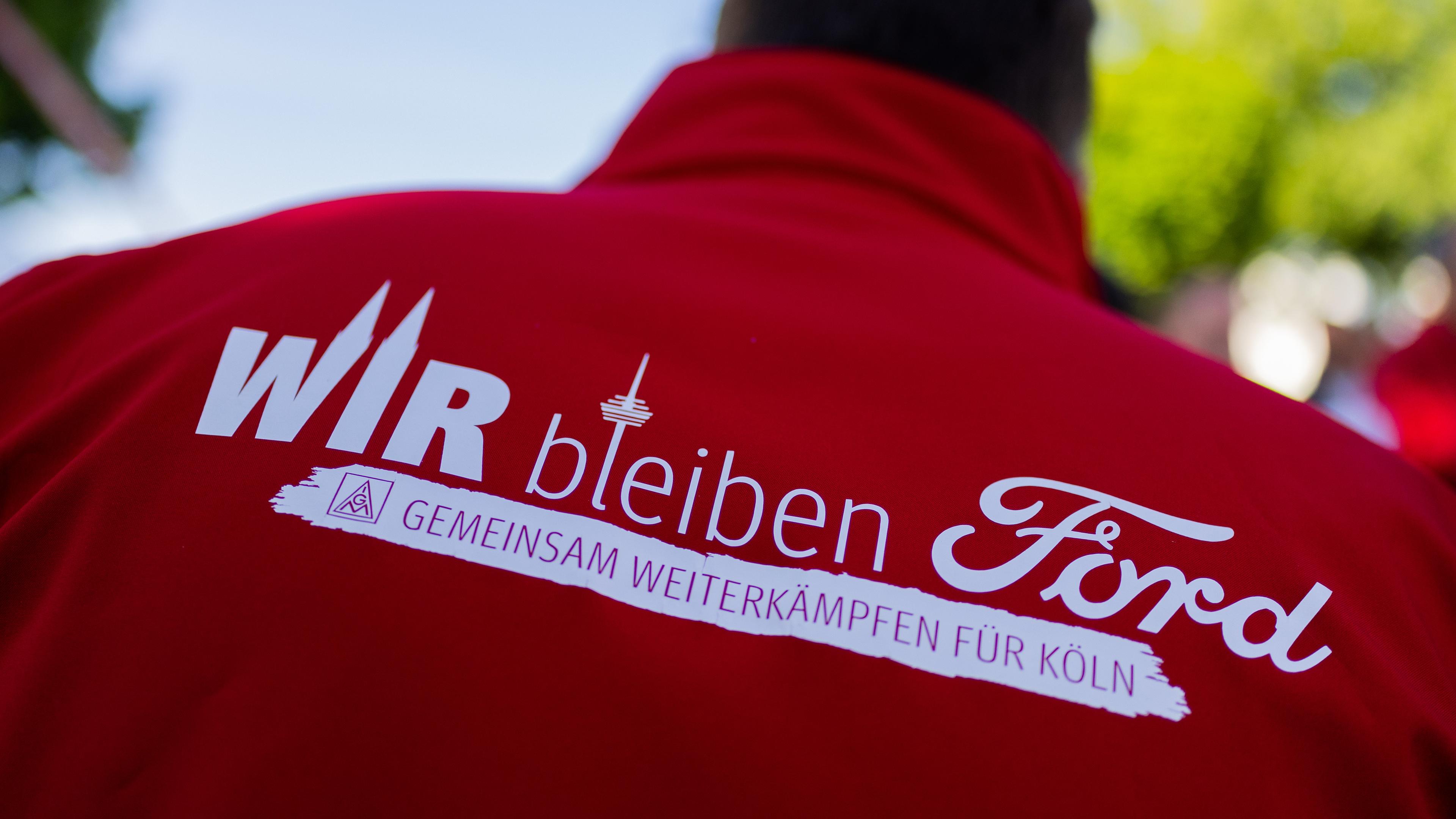 Ein Mitarbeiter trägt eine Jacke mit der Aufschrift Wir bleiben Ford - Gemeinsam weiterkämpfen für Köln beim ersten Streik der Geschichte vor den Kölner Ford-Werken.