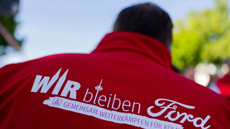 Ein Mitarbeiter trägt eine Jacke mit der Aufschrift Wir bleiben Ford - Gemeinsam weiterkämpfen für Köln beim ersten Streik der Geschichte vor den Kölner Ford-Werken.