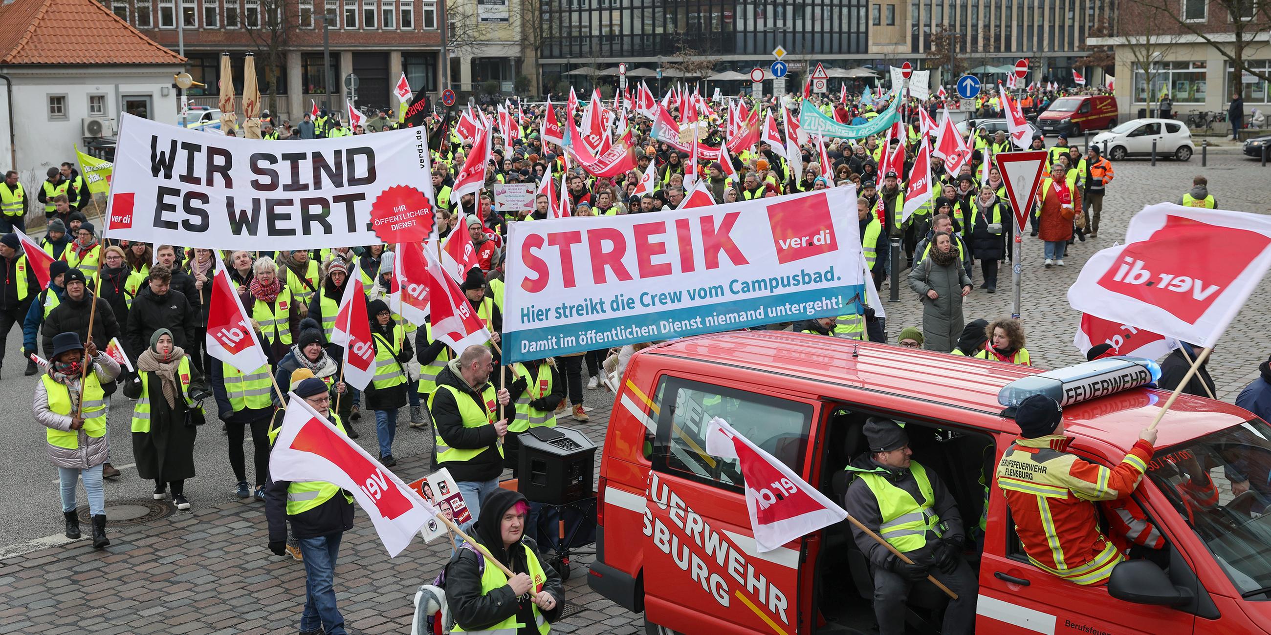 Teilnehmer eines Warnstreiks verschiedener Gewerkschaften laufen in einem Demonstrationszug durch die Innenstadt Kiels
