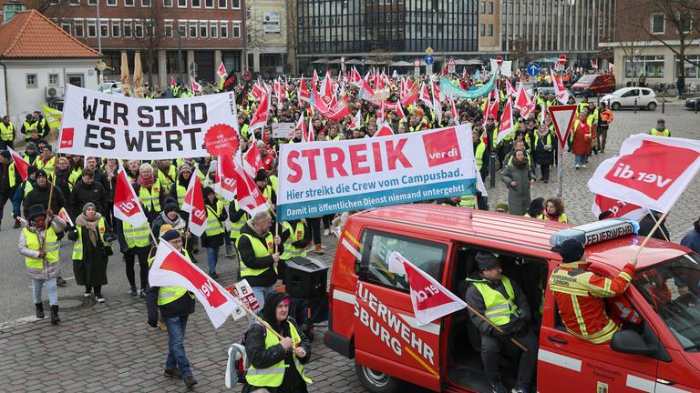 Teilnehmer eines Warnstreiks verschiedener Gewerkschaften laufen in einem Demonstrationszug durch die Innenstadt Kiels