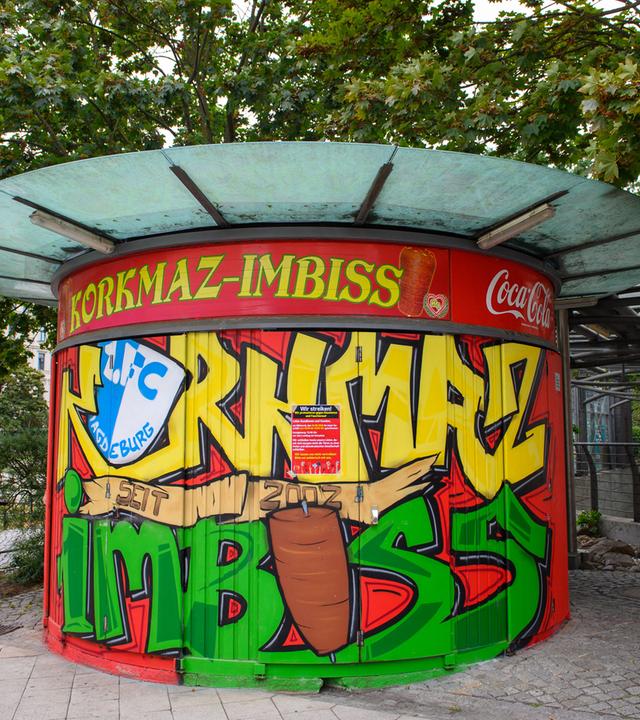 Migrantinnen und Migranten streiken gegen Rassismus. Ein geschlossener von migrantischen Gewerbetreibenden betriebenen Imbiss. Am Laden ist ein Plakat zu sehen auf dem "Wir streiken!" und "Wir protestieren gegen Rassismus und Faschismus." zu lesen ist.