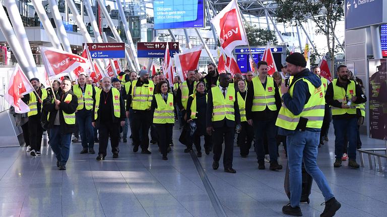 Warnstreik der Beschaeftigten im Luftsicherheitsbereich am 10.03.2025 am Flughafen Duesseldorf in Duesseldorf Mitglieder der Gewerkschaft Verdi laufen mit Fahnen bei einem Streik in einem Teminal des Duesseldorfer Flughafens. Die Gewerkschaft Verdi hat die Beschaeftigten des oeffentlichen Dienstes und der Bodenverkehrsdienste fuer Montag zu einem 24-stuendigen Warnstreik an 13 Flughaefen aufgerufen. 