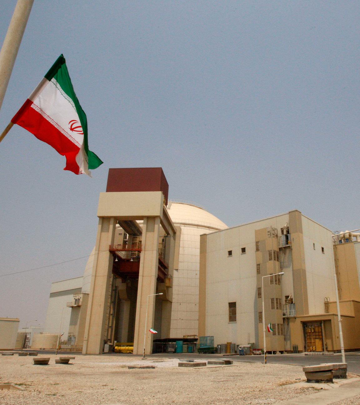 Eine iranische Flagge flattert vor dem Reaktorgebäude des Kernkraftwerks Buscher. 