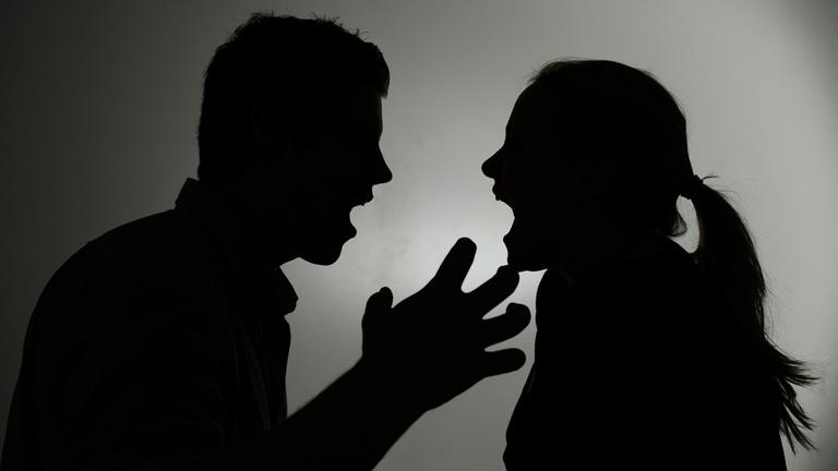 Ein Mann und eine Frau streiten und schreien sich an.