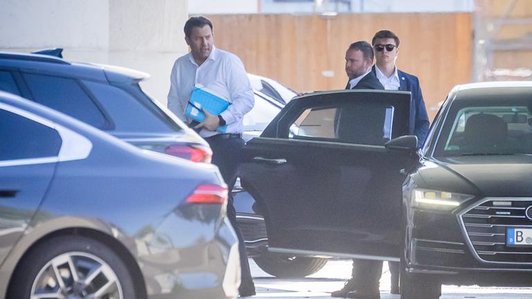 Lars Klingbeil verlässt in weißem Hemd sein Regierungsfahrzeug