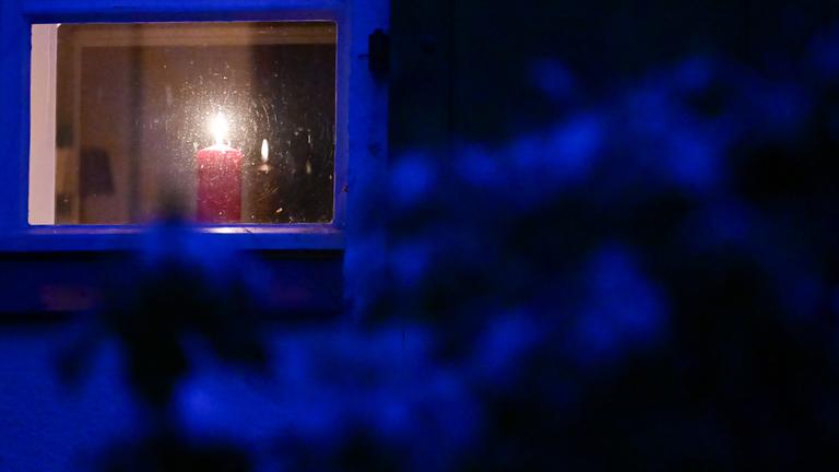 Eine Kerze steht während eines Stromausfalls im Südwesten Berlins in einem Fenster.
