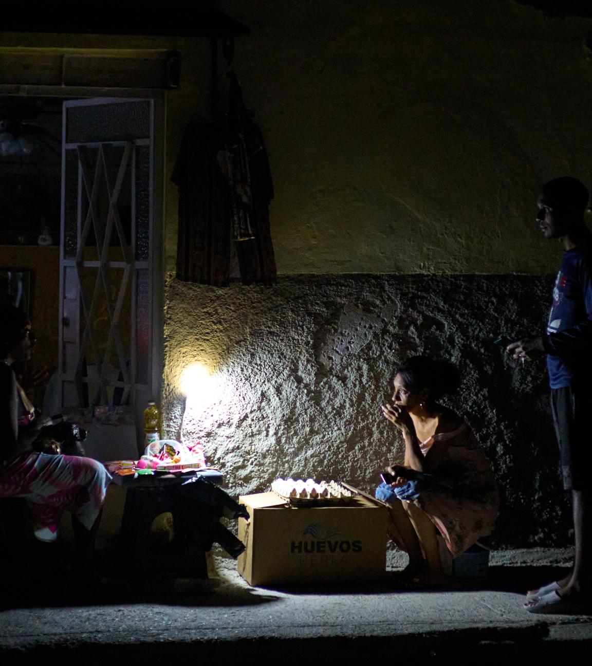 Straßenverkäufer unterhalten sich während eines Stromausfalls in Havanna