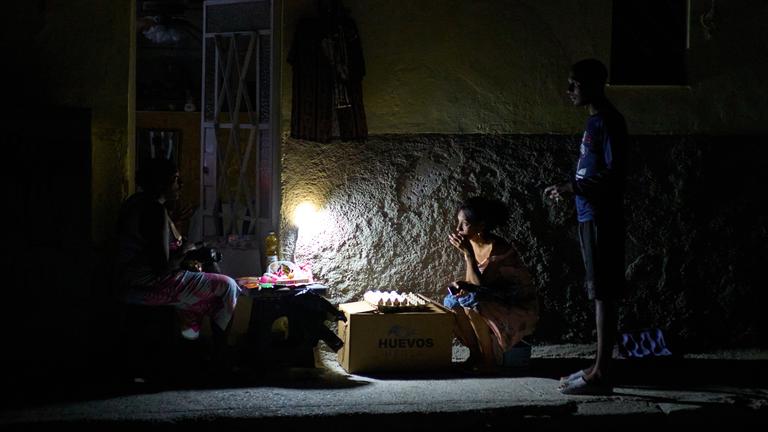 Straßenverkäufer unterhalten sich während eines Stromausfalls in Havanna