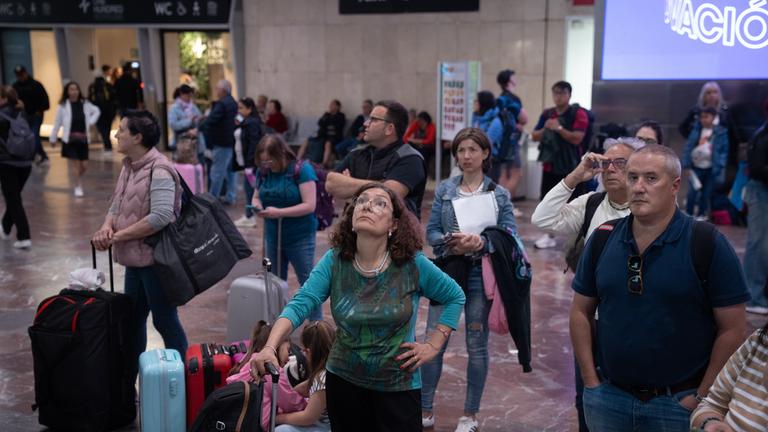 Mehrere Menschen warten am Bahnhof Sants nach dem Stromausfall.