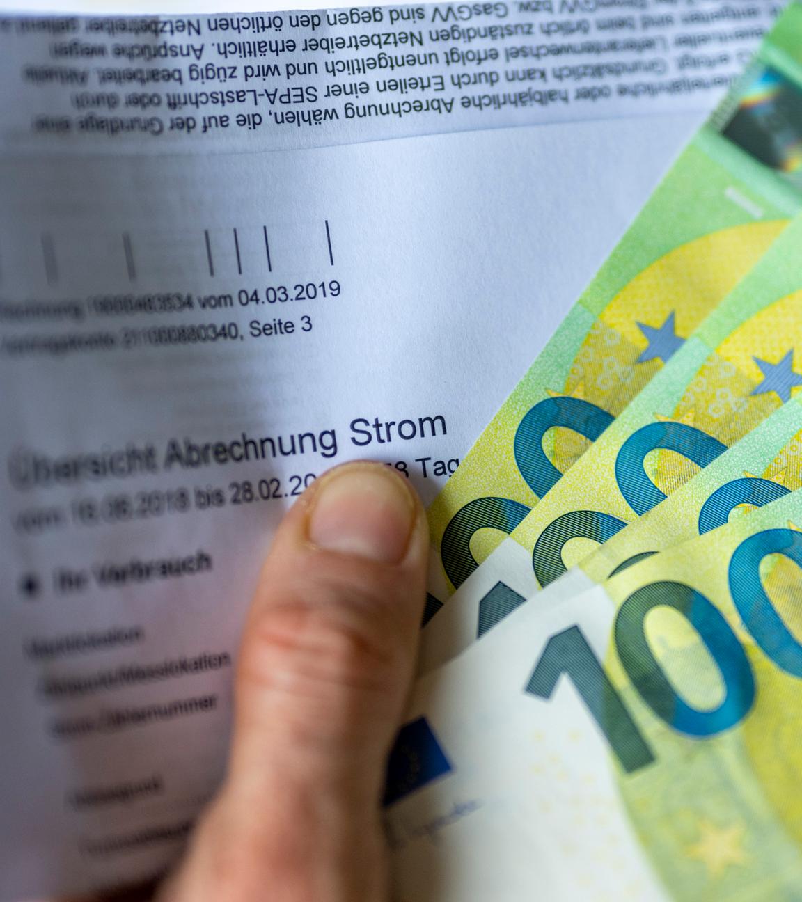 Symbolbild: Stromrechnung mit Geldscheinen - hohe Strompreise