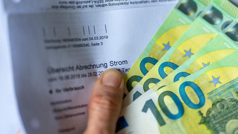 Symbolbild: Stromrechnung mit Geldscheinen - hohe Strompreise