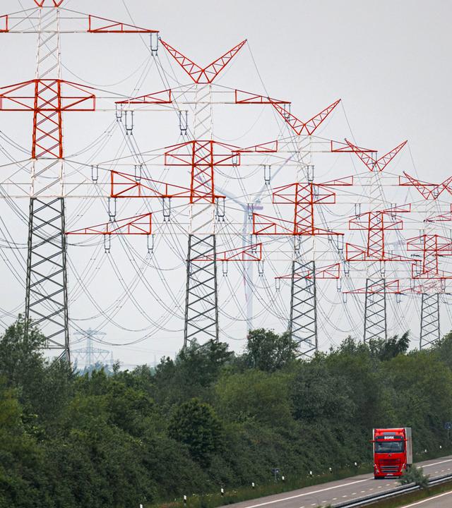  Hochspannungsmasten und Stromleitungen verlaufen entlang Schnellstraße.