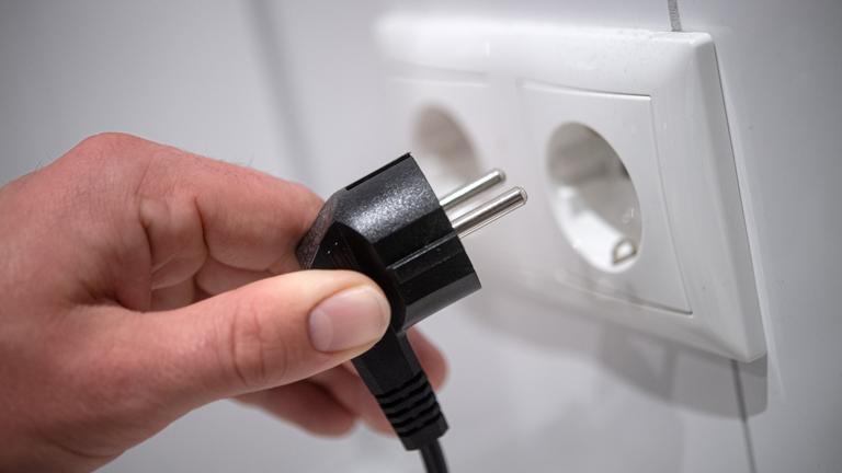 Strompreis, Symbolbild. Ein Stecker wird in eine Steckdose gesteckt. 
