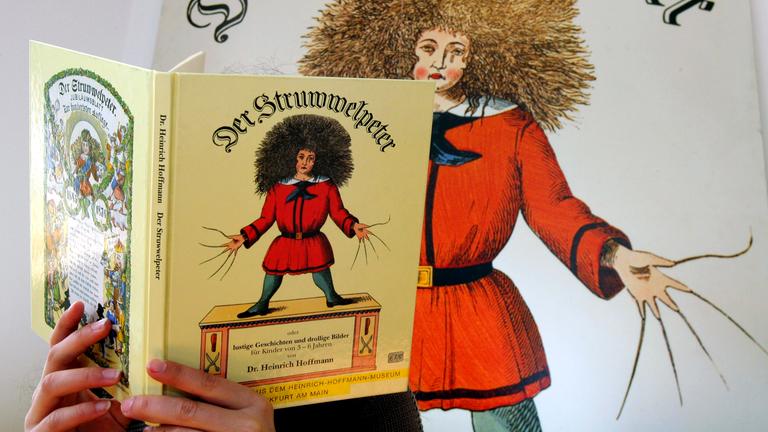Besucherin blättert in einem Struwwelpeter-Buch im Struwwelpeter-Museum in Frankfurt am Main.