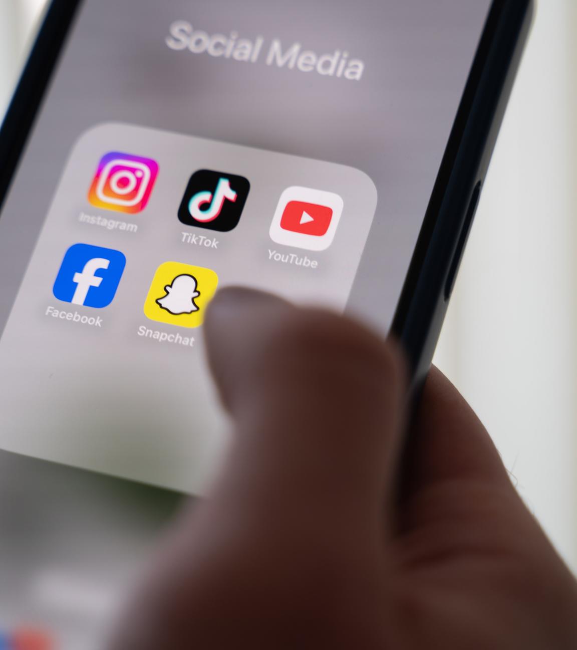 24.10.2024, Niedersachsen, Hannover: Eine Frau hält ein Smartphone, auf dessen Display verschiedene Social Media Apps angezeigt werden. 