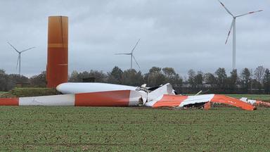 Nach dem Sturm liegt das abgebrochene Rotorblatt einer Windkraftanlage auf einem Feld. 