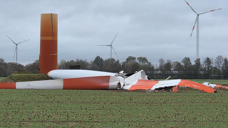 Nach dem Sturm liegt das abgebrochene Rotorblatt einer Windkraftanlage auf einem Feld. 