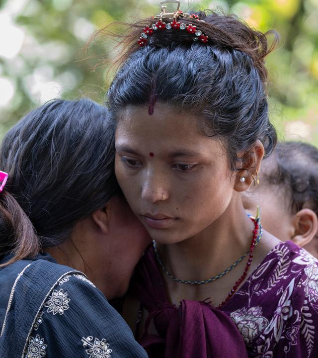 Angehörige von Flutopfern stehen vor dem Armeestützpunkt, in den Überlebende nach einer Sturzflut im Dorf Devighat im nepalesischen Distrikt Nuwakot per Hubschrauber gebracht werden.