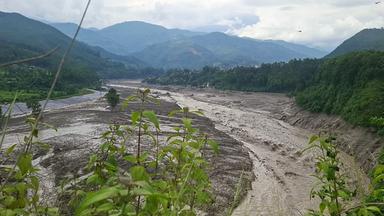 Eine Flut aus schlammigem Wasser wälzt sich am 26. August 2026 nach Sturzfluten im nepalesischen Distrikt Nuwakot durch den Fluss Trishuli.
