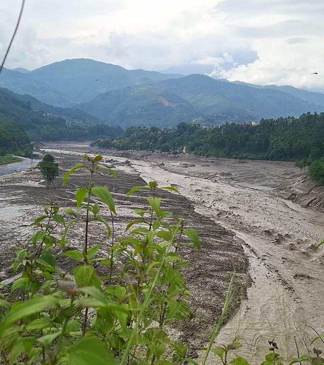 Eine Flut aus schlammigem Wasser wälzt sich am 26. August 2026 nach Sturzfluten im nepalesischen Distrikt Nuwakot durch den Fluss Trishuli.
