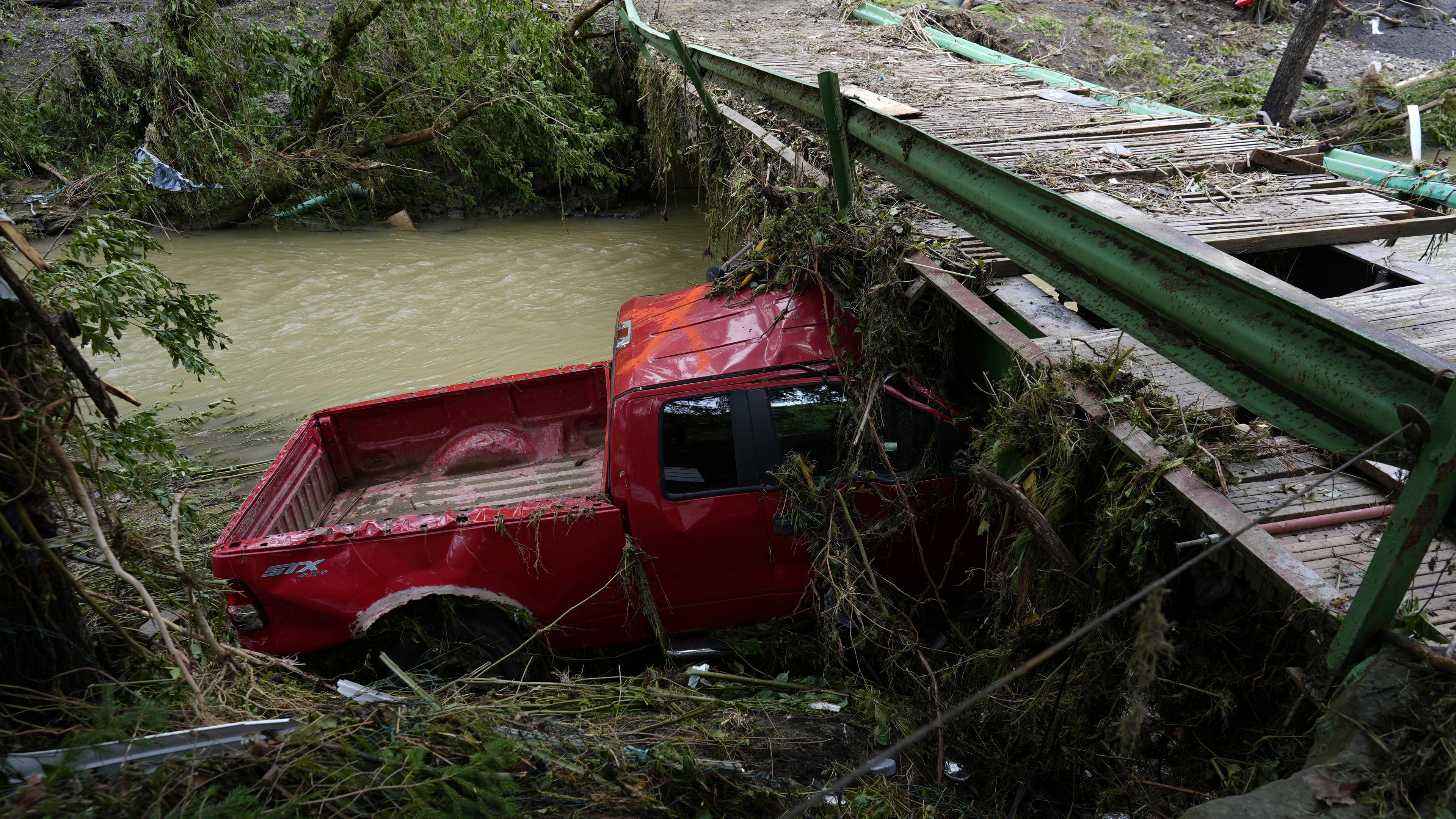 Ein Auto steckt nach Sturzfluten in Schutt fest.
