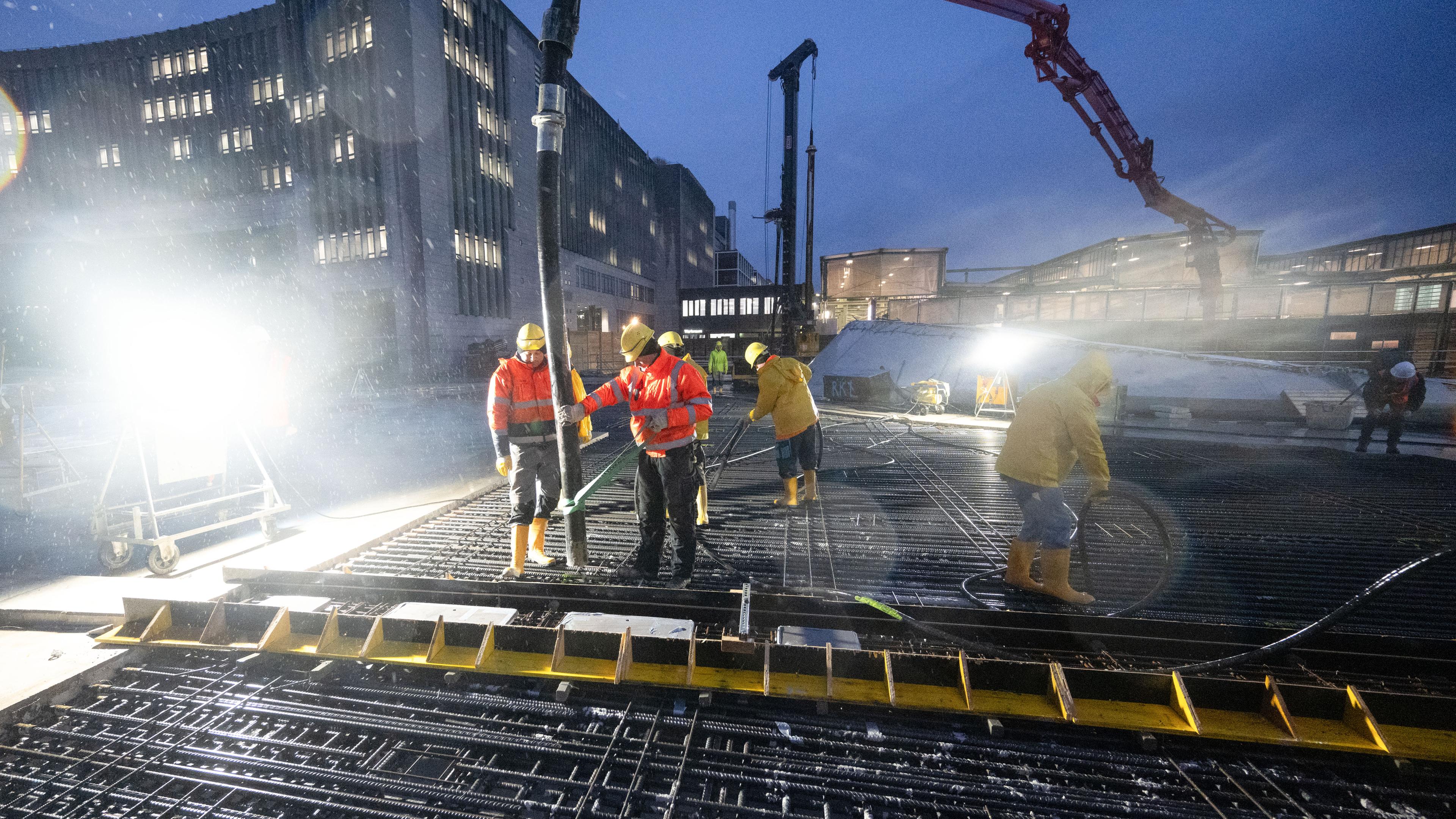 Arbeiter betonieren das letzte Stück des Dachs des neuen Tiefbahnhofs im Rahmen des milliardenschweren Bahnprojekts Stuttgart 21 am 28.11.2023.