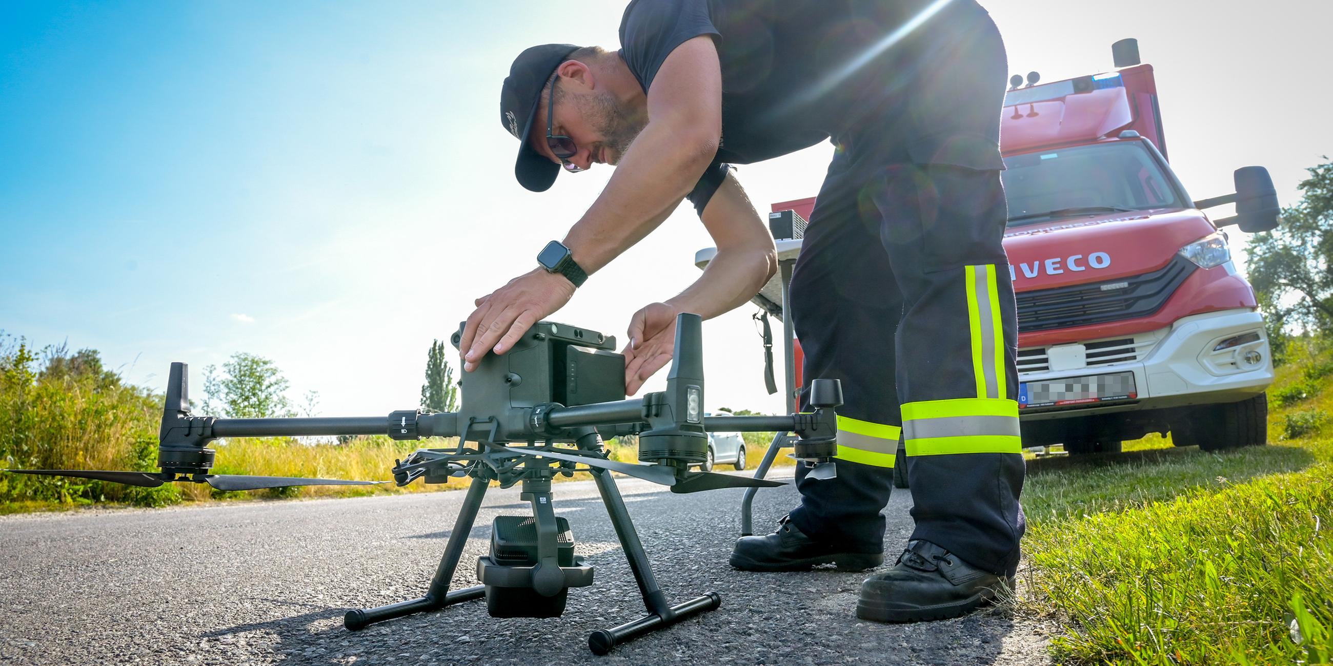 Sachsen-Anhalt, Braunsbedra: Feuerwehrleute der Feuerwehr Braunsbedra suchen ein Gelände weiträumig mit Drohnen ab.