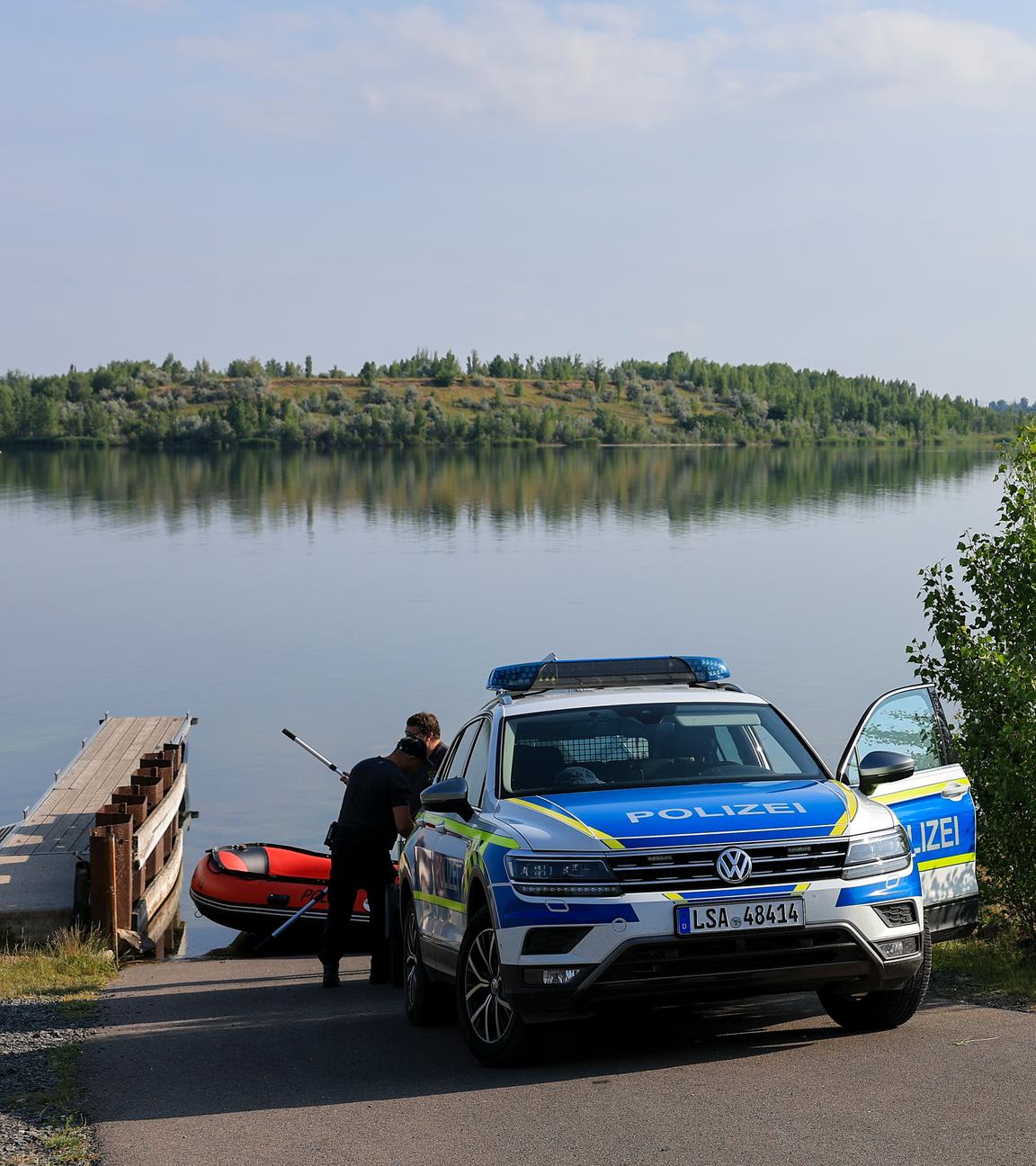 Polizisten bereiten ein Schlauchboot am Geiseltalsee vor.