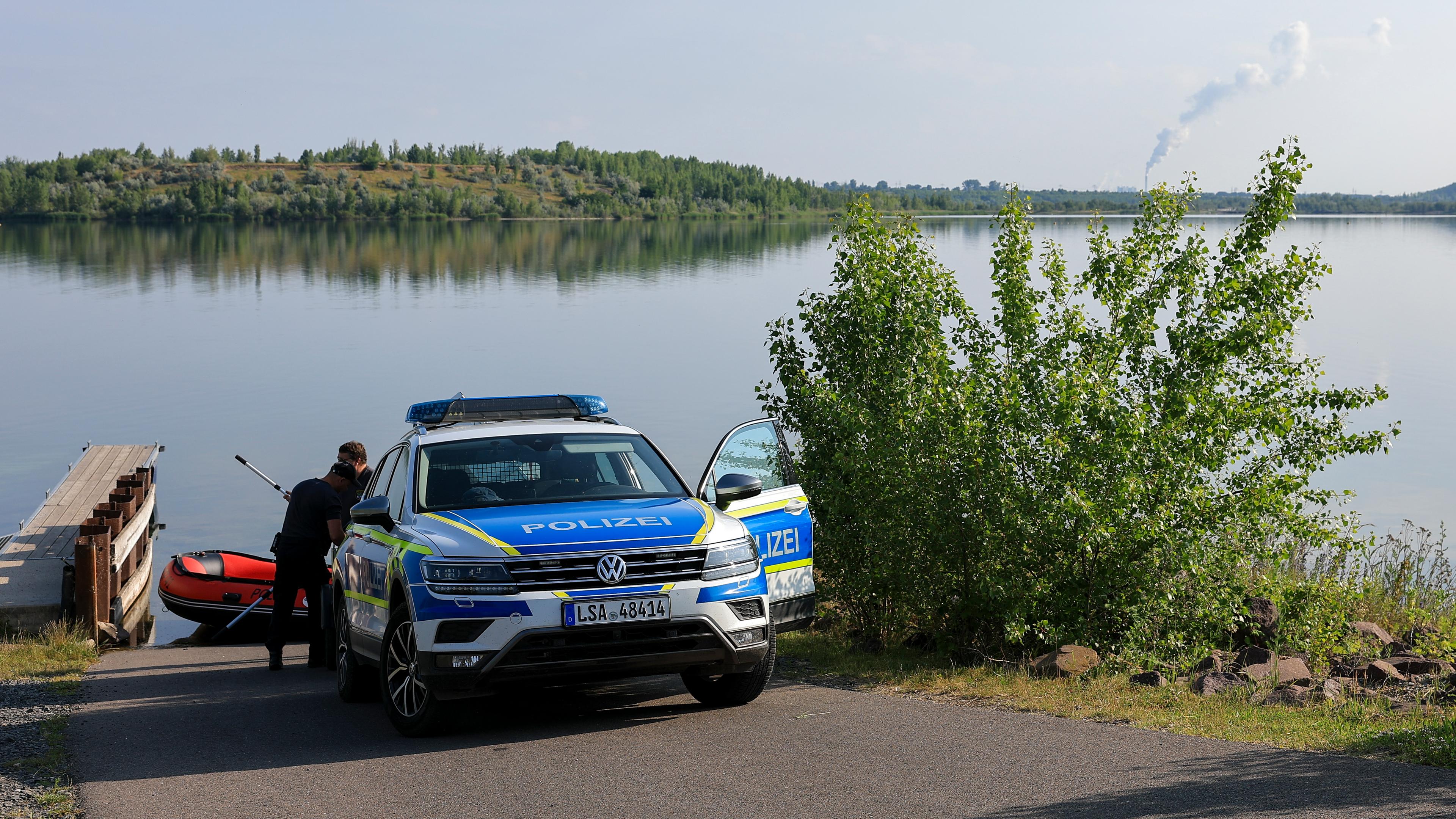 Polizisten bereiten ein Schlauchboot am Geiseltalsee vor.