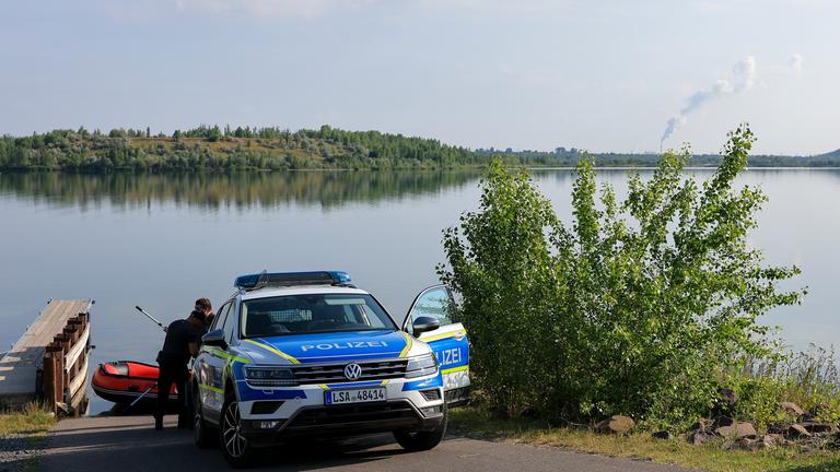 Polizisten bereiten ein Schlauchboot am Geiseltalsee vor.