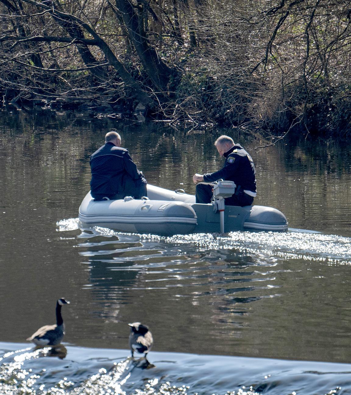 Von einem Schlauchboot aus suchen Polizisten die Lahn ab