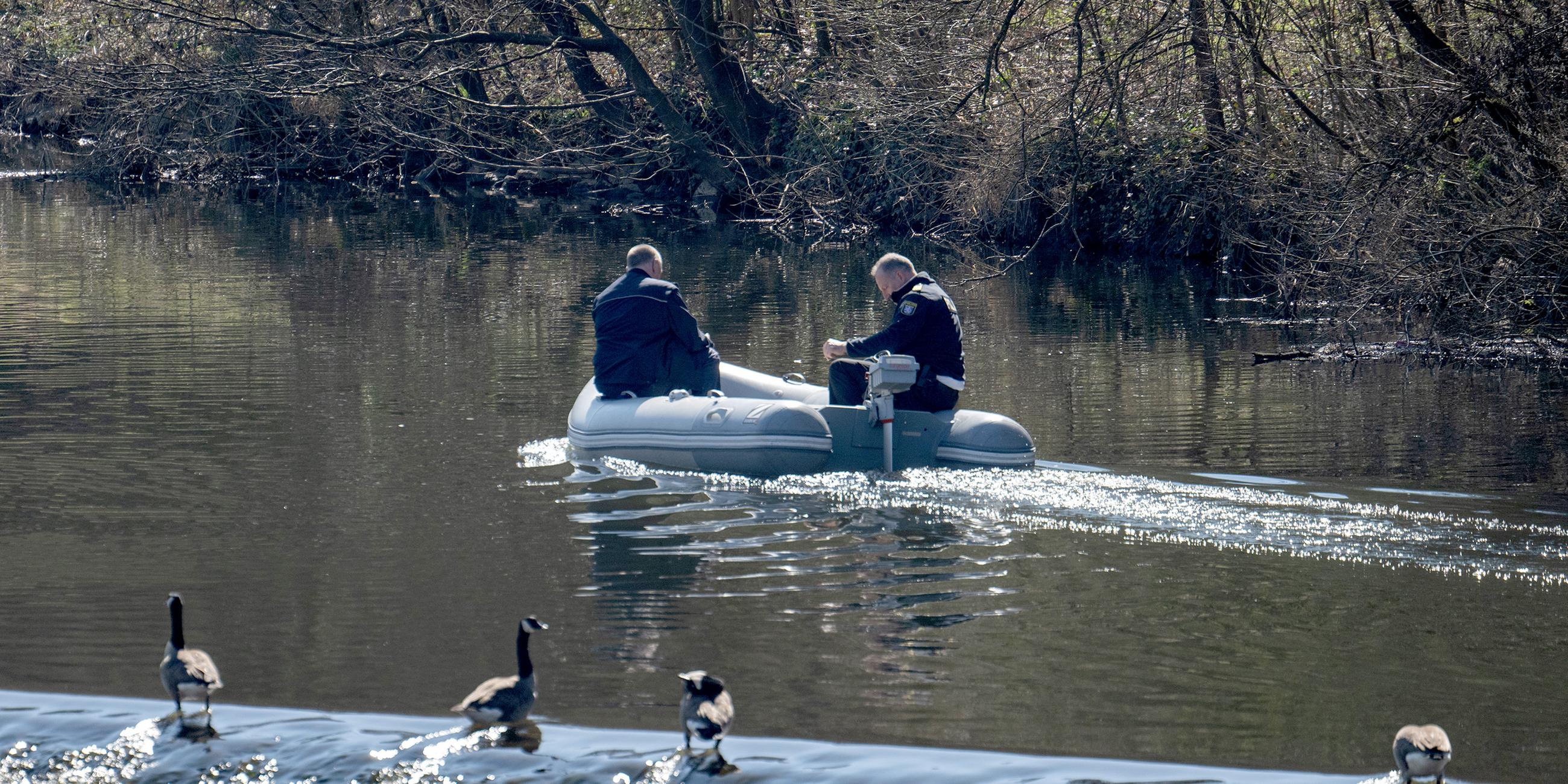 Von einem Schlauchboot aus suchen Polizisten die Lahn ab