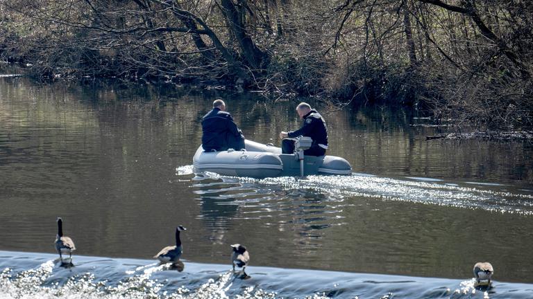 Von einem Schlauchboot aus suchen Polizisten die Lahn ab