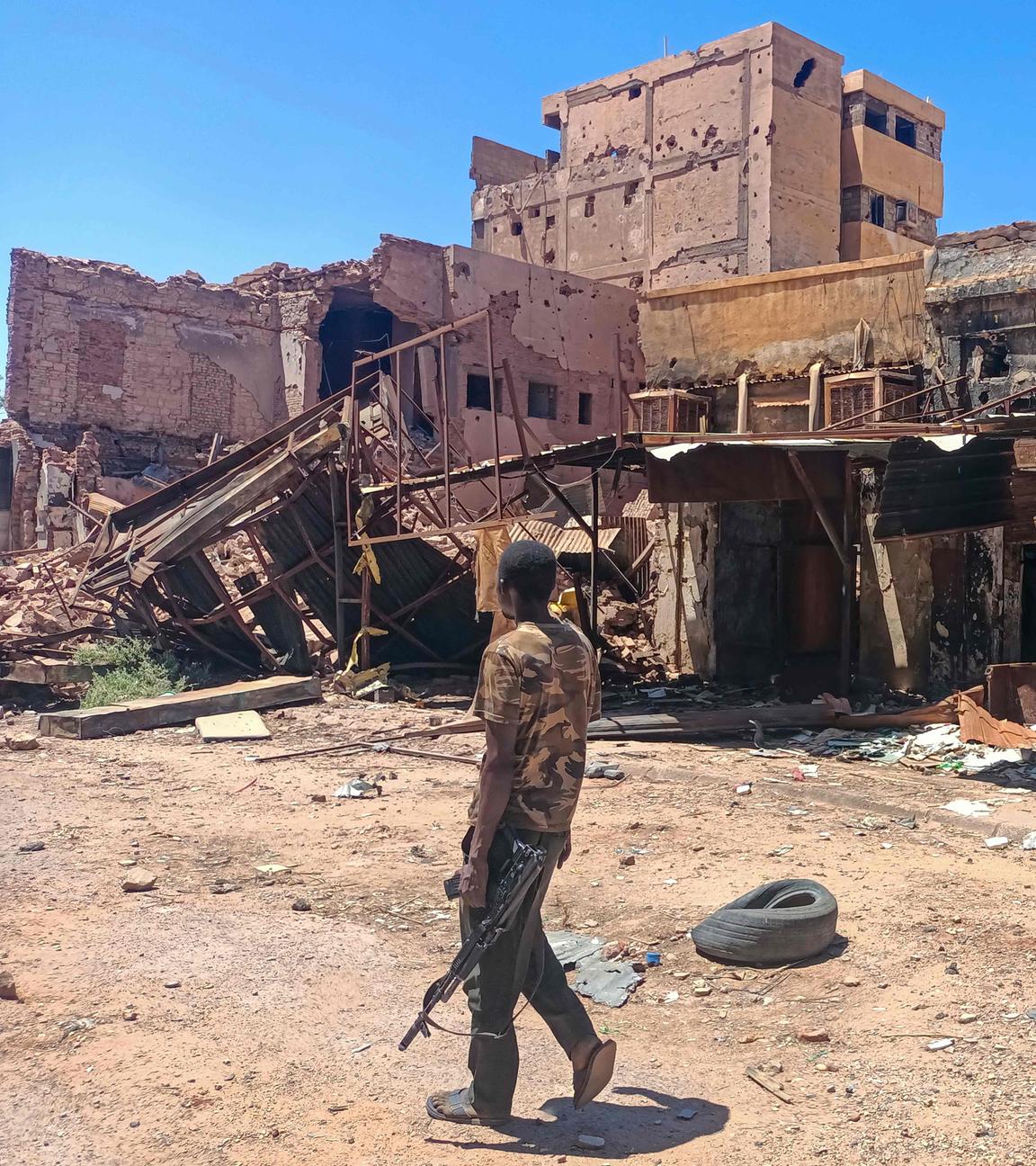 Ein sudanesische Soldat geht an einem beschädigten Gebäude in Kartoum vorbei.