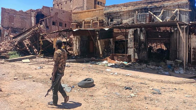 Ein sudanesische Soldat geht an einem beschädigten Gebäude in Kartoum vorbei.