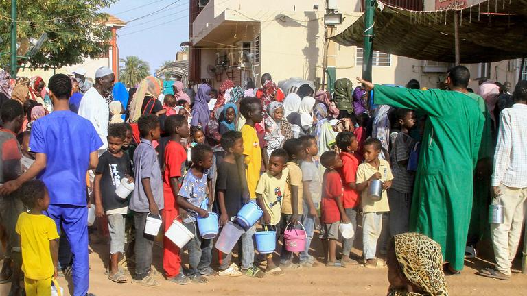 Sudanesen in Omdourman stehen Schlange, um ein wohltätiges Iftar-Essen zu sammeln, aufgenommen am 19.03.2025
