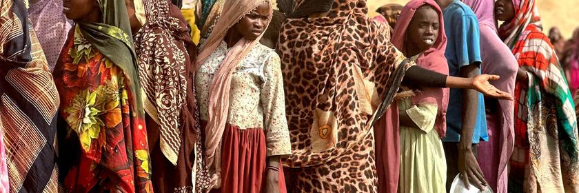 Menschen stehen in einem provisorischen Lager auf einem offenen Feld nahe der sudanesischen Stadt Tawila für Lebensmittelrationen Schlange