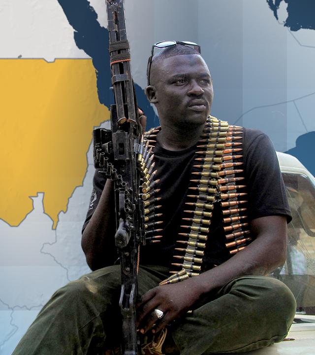 Ein Kämpfer sitzt mit einem Gewähr in der Hand auf einem Fahrzeug, im Hintergrund eine Landkarte Afrikas