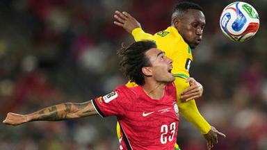 Der Südkoreaner Jens Castrop (l, 23) springt gemeinsam mit dem Südafrikaner Thapelo Maseko (12) zum Ball. 