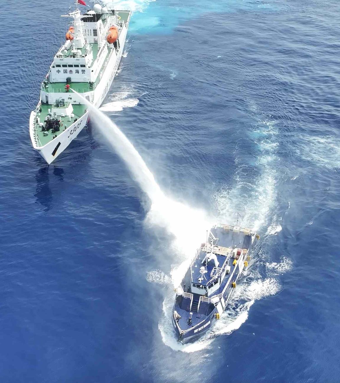 Zwei Schiffe auf hoher See: das größere beschießt das kleinere mit einem starken Wasserwerfer.