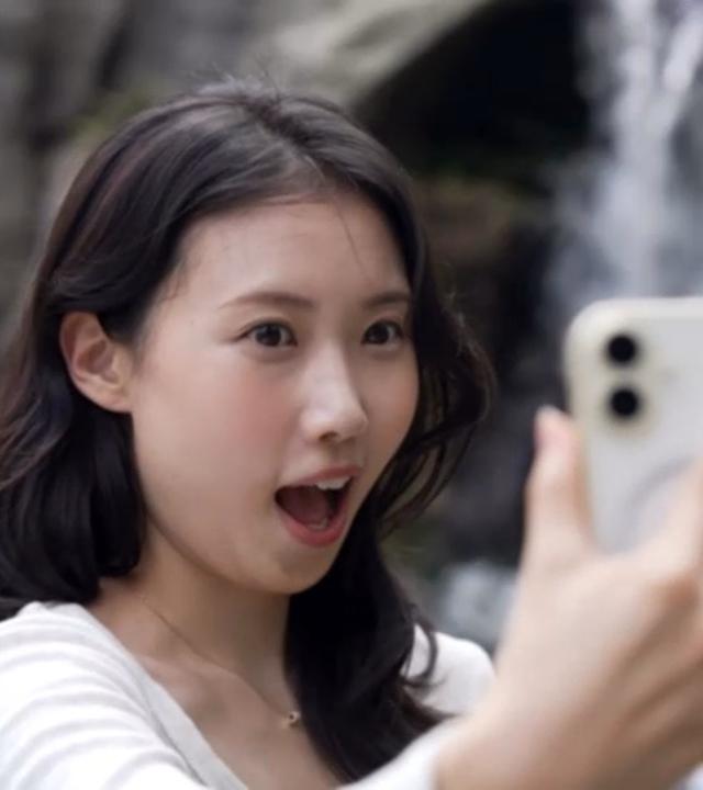 Influencerin Jihye Jung aus Südkorea spricht in ihr Smartphone.